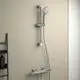 Brausearmatur von Ideal Standard mit Handbrause, verstellbarer Halterung und zwei Bedienelementen, montiert an einer hellen Wand.
